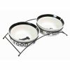 Comedero y bebedero cerámica. Dos comederos para perros, elaborados en cerámica, con soporte metálico lacado en color negro. Antideslizante de caucho en la base. Ideal para proporcionarle el alimento a tus perros de manera efectiva y adecuada. La cerámica mantiene la temperatura de la comida y el agua. Los comederos van de corados con dibujos en negro con el fondo blanco. Disponible en dos tamaños. Pequeño -- 0,25L - 13cm de diametro Mediano -- 0,6L - 15cm de diametro